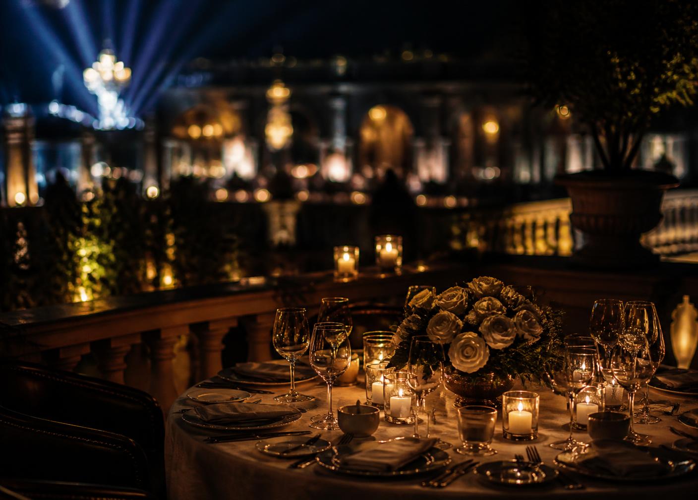 Candlelit private dining table on a terrace at night